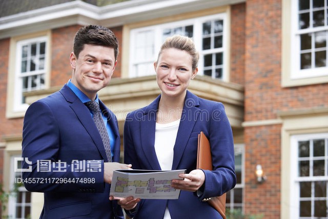 站在住宅物業外面的男女房地產經紀人Male And Female Realtor Standing Outside Residential Property